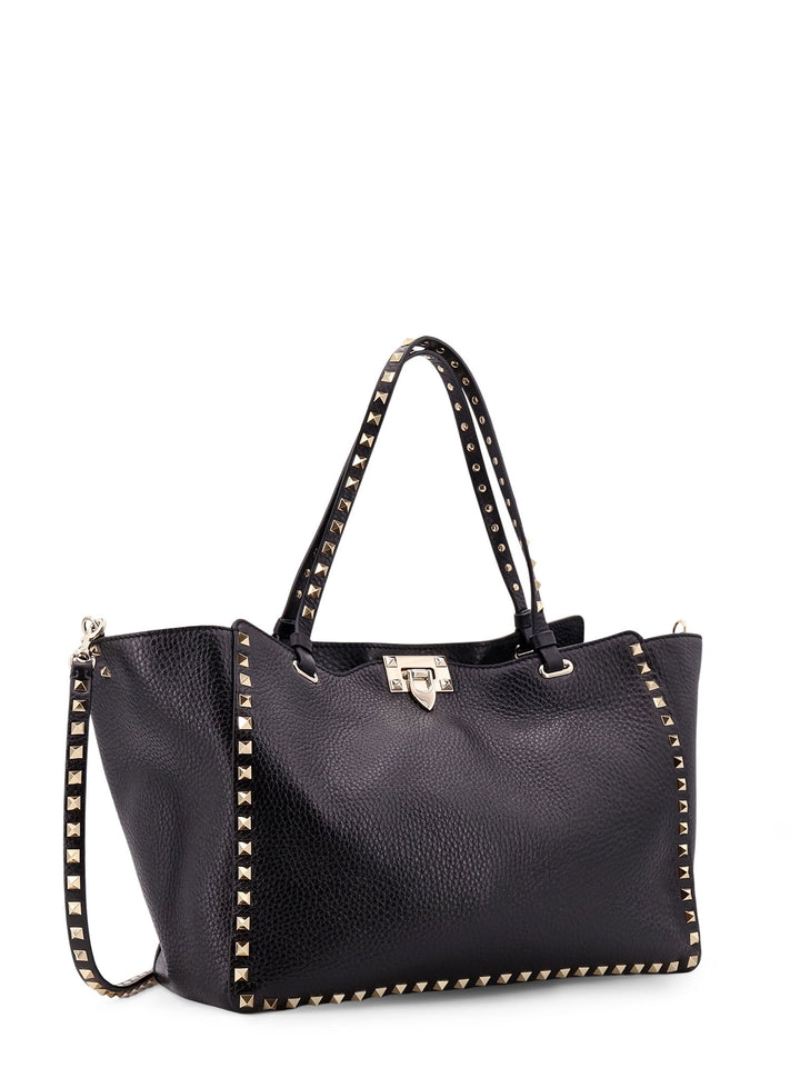 Hammered leather shoulder bag with iconic studs, metal hook closure and removable shoulder strap