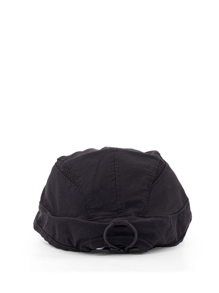 Technical fabric peaked hat with perforated fabric inserts